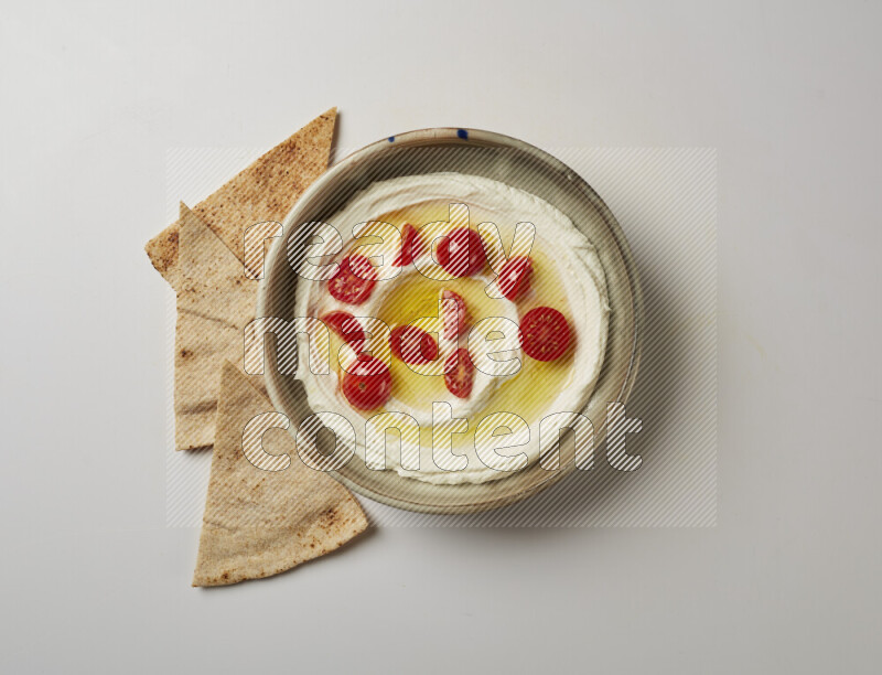 Lebnah garnished with cherry tomato in a grey pottery plate on a white background