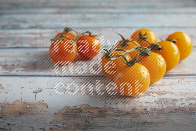 Mixed cherry tomato veins on a textured light blue wooden background 45 degree