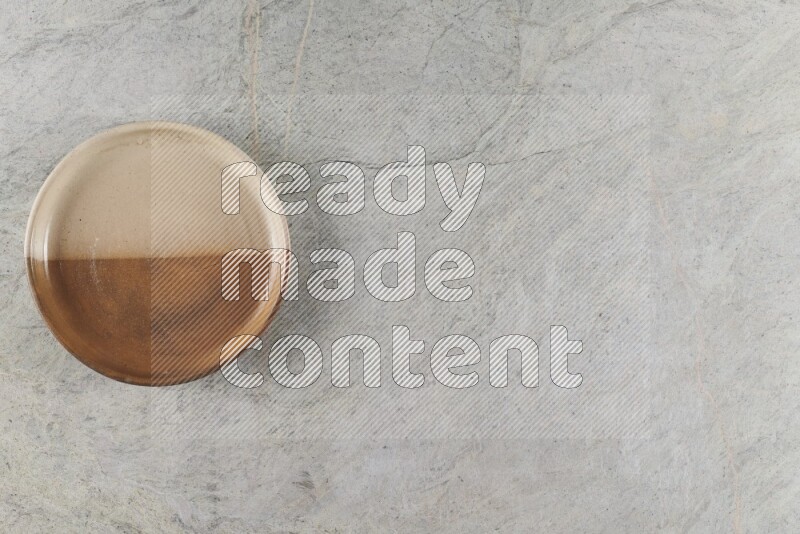 وعاء فرن فخاري متعدد الألوان على خلفية من الرخام الرمادي