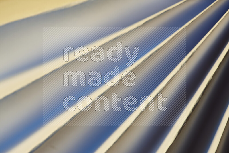 An image presenting an abstract paper pattern of lines in blue and gold tones