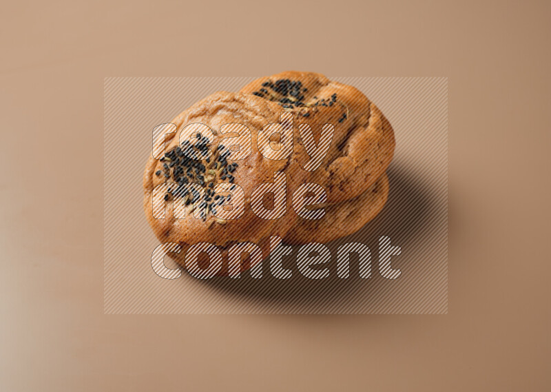 Hasawi cookies field with date and decorated by black seed and Anise grain on a brown background
