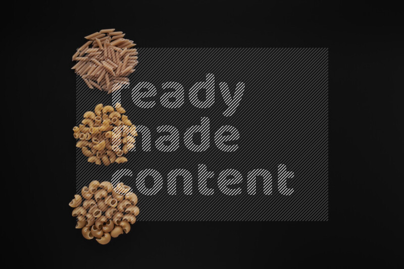 Different pasta types in 3 bunches on black background