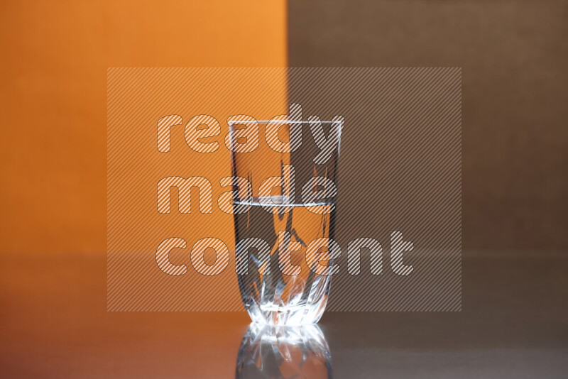 The image features a clear glassware filled with water, set against orange and brown background