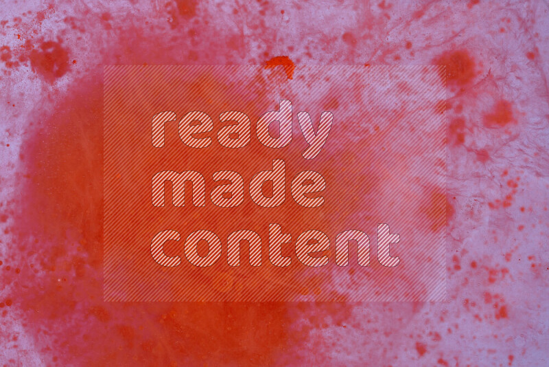 The image captures a dramatic splatter of red paint over a white backdrop