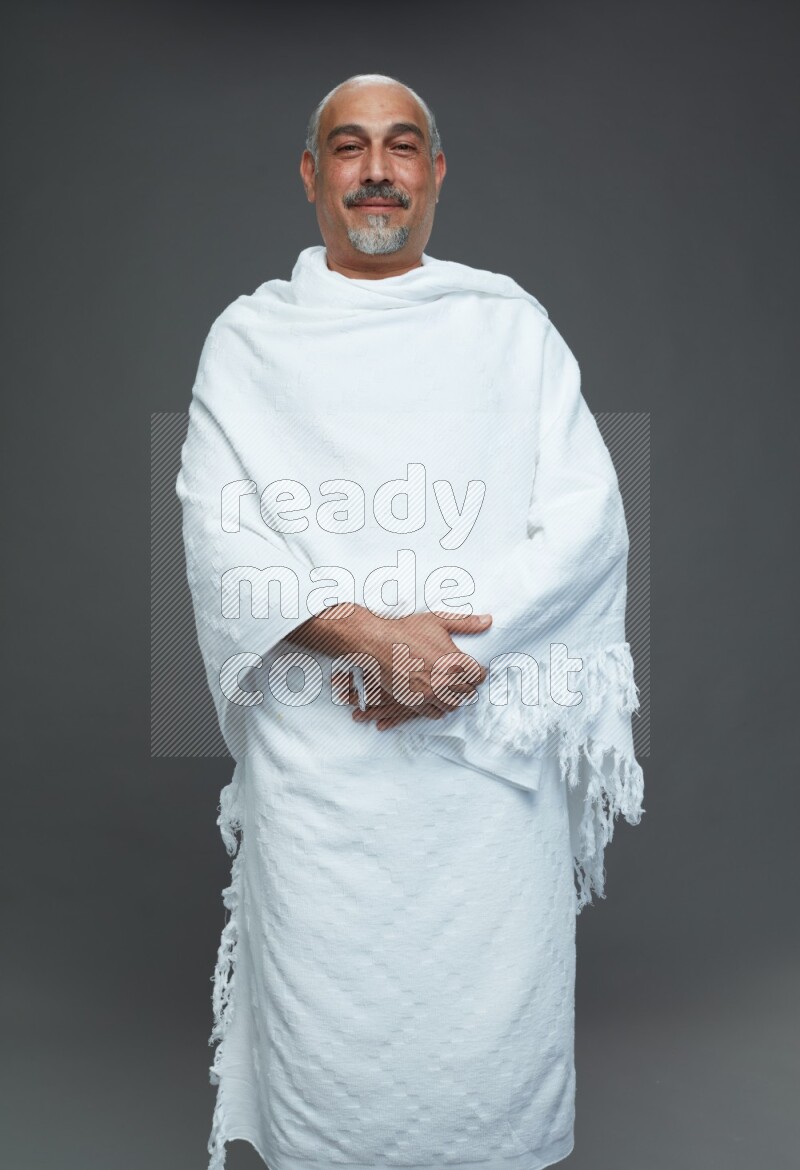 A man wearing Ehram Standing Interacting with the camera on gray background
