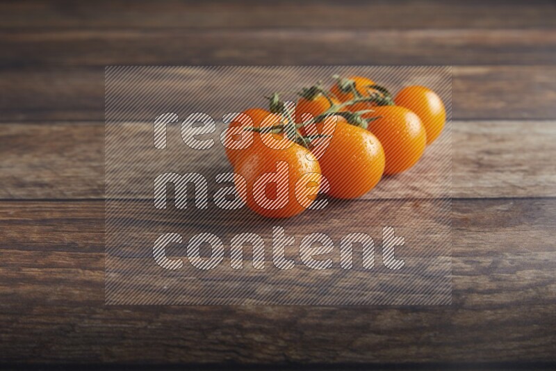 Orange cherry tomato vein on a textured wooden background 45 degree