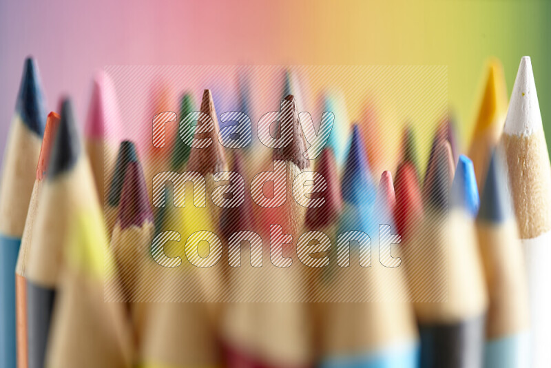 The image captures a close-up of sharpened colored pencils on multicolored background