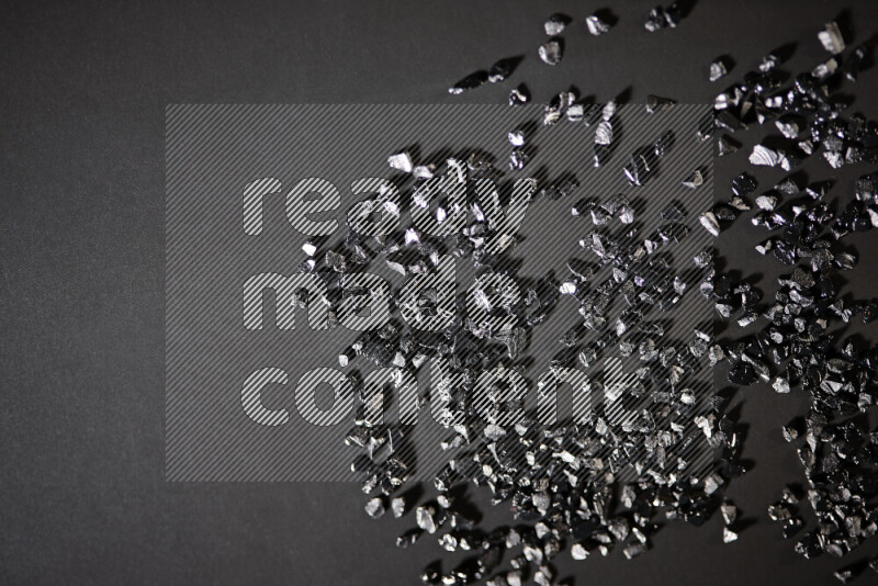 قطع زجاجية سوداء لامعة متناثرة على خلفية سوداء