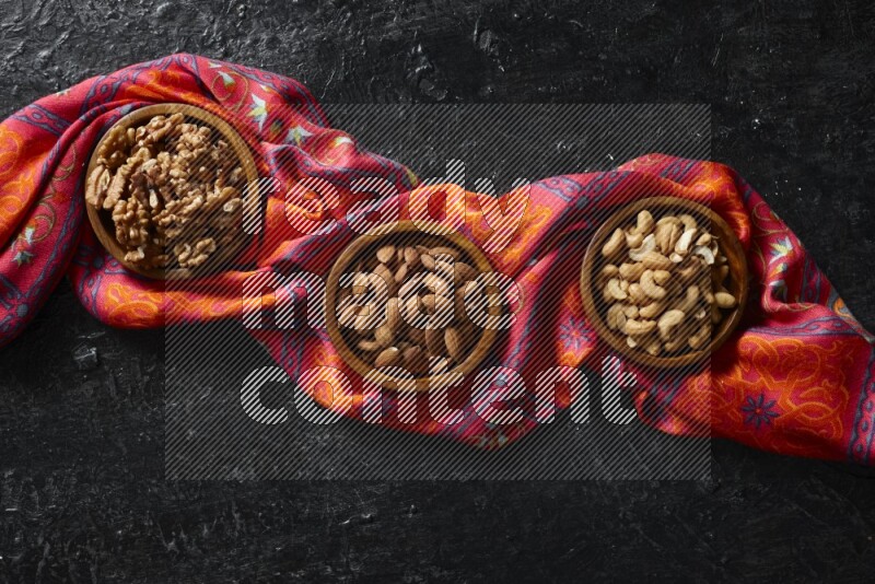 Nuts in wooden bowls in a dark setup