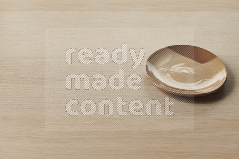 A multicolored pottery plate on light wooden background