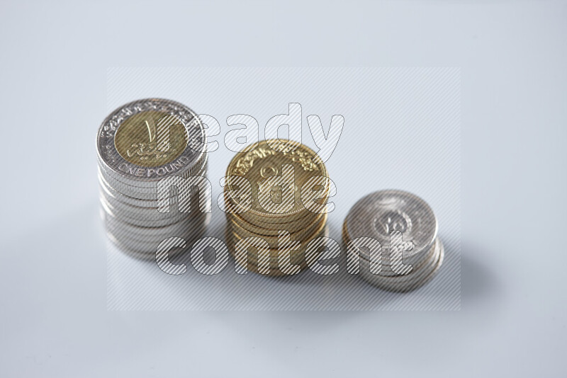A close-up of scattered mixed Egyptian coins such as One pound, 50 and 25 piasters on grey background