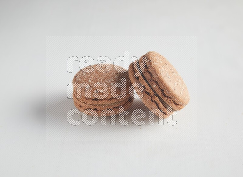 45º Shot of two Brown Hazelnuts macarons on white background