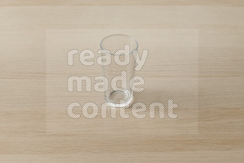An empty glass cup on light wooden background