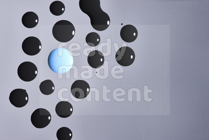 Close-ups of abstract blue and black paint droplets on the surface