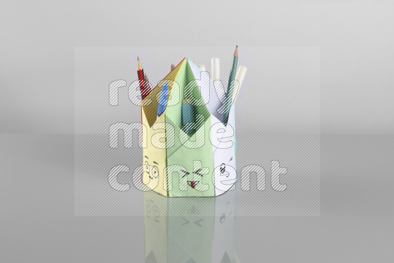 Origami pen holder on grey background