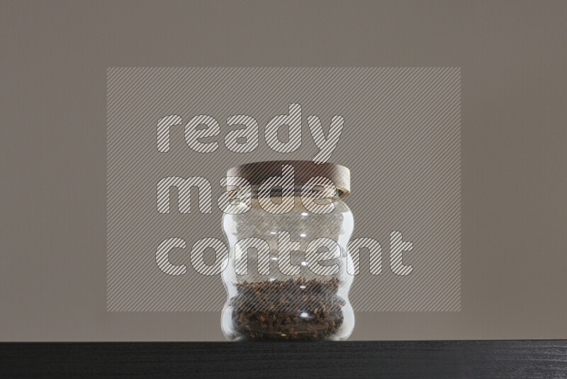 Dried basil in a glass jar on black background
