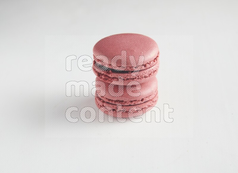 45º Shot of two Pink Raspberry macarons on white background