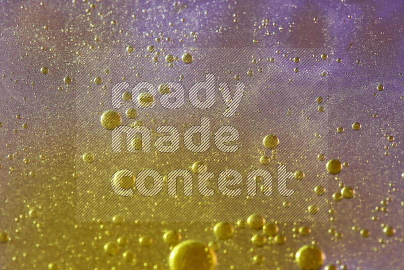 Close-ups of abstract yellow watercolor drops on oil Surface on pink background