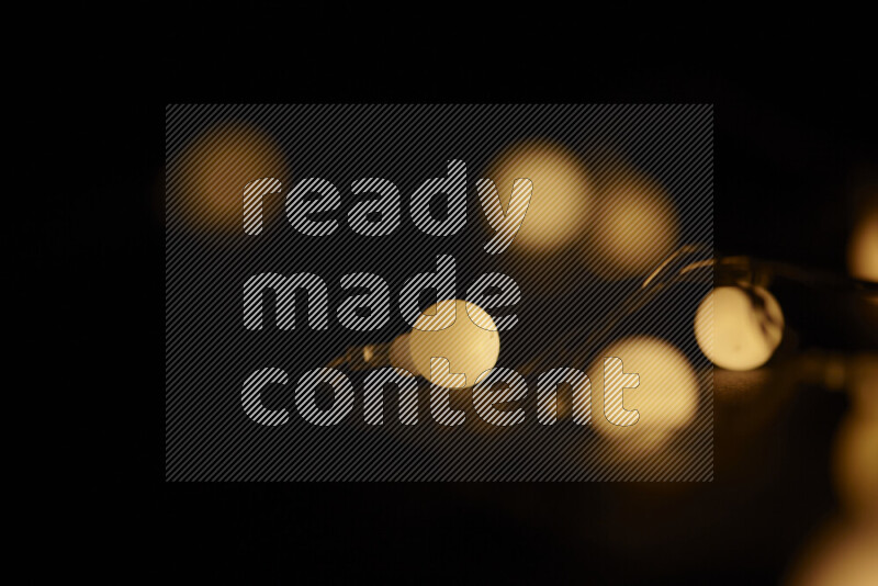 Light bulbs glowing against backdrop of golden bokeh