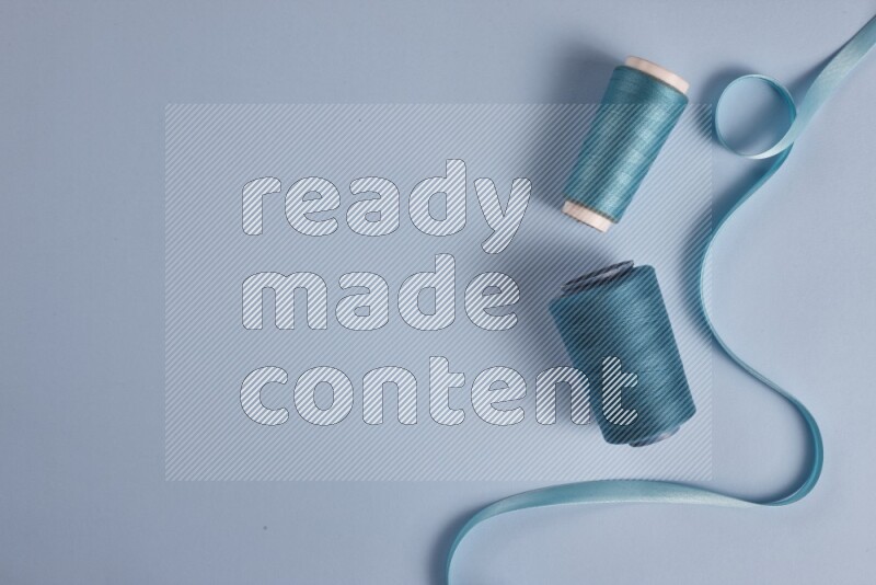 A blue collection of sewing and tailoring tools arranged on a blue background