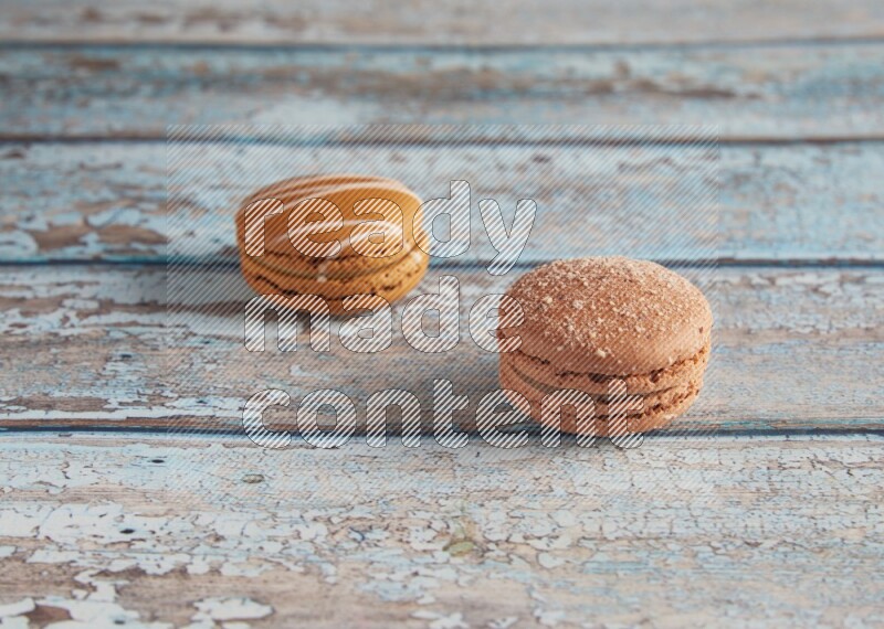 45º Shot of of two assorted Brown Irish Cream, and Brown Hazelnuts macarons  on light blue background