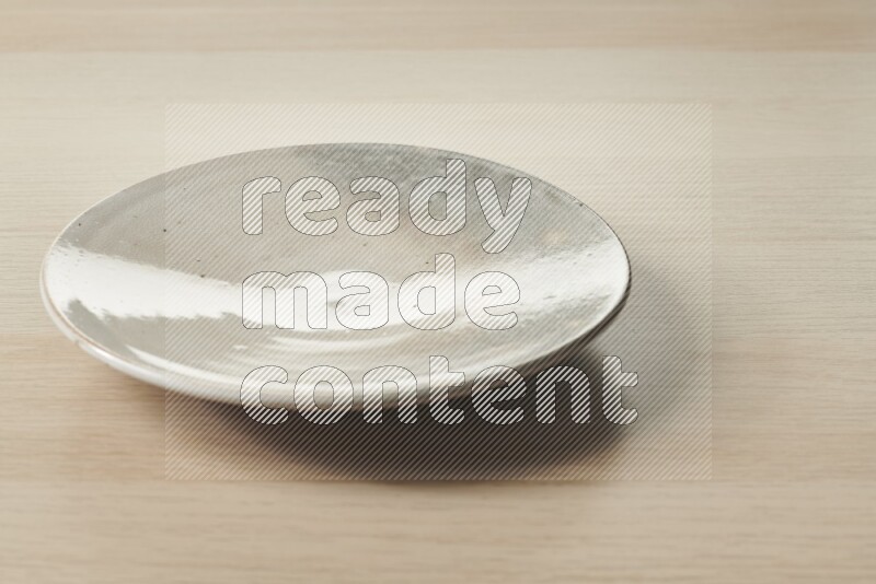 صحن فخاري متعدد الألوان على خلفية خشبية فاتحة