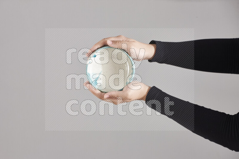 A woman in black abaya holding different pottery essentials in different positions
