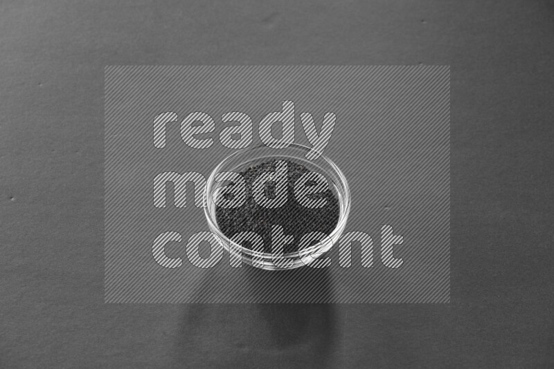 حبة البركة في وعاء زجاجي علي خلفية سوداء