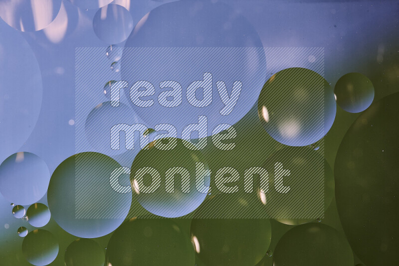 Close-ups of abstract oil bubbles on water surface in shades of blue and green
