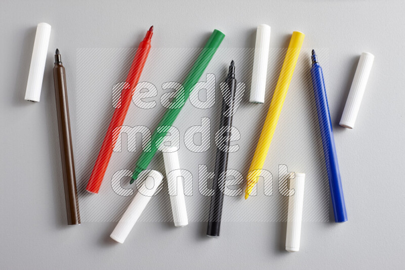 An arrangement of coloring pens in different colors on grey background