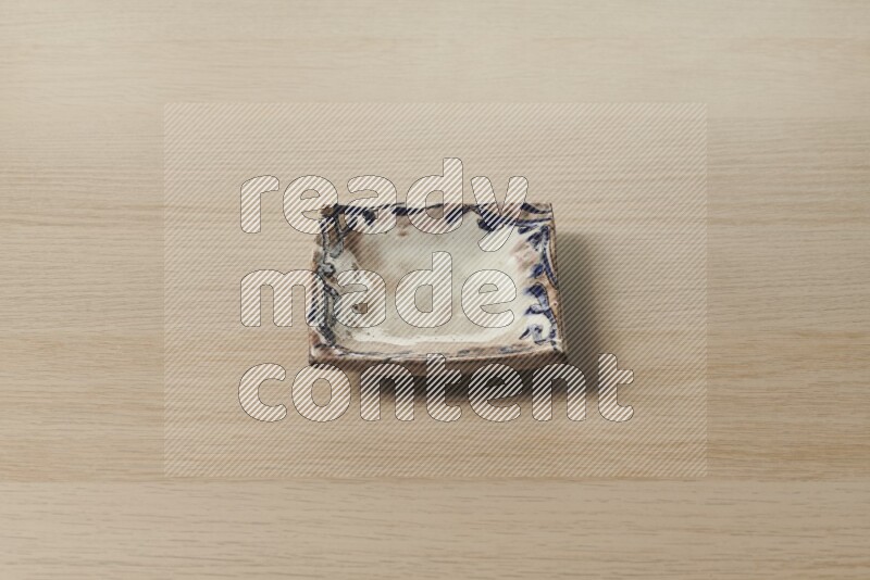 A decorative pottery plate on light wooden background