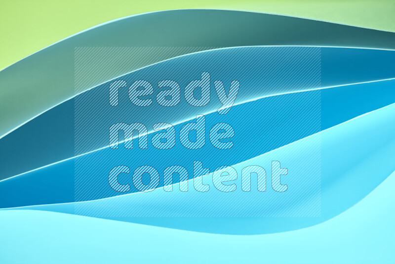 This image showcases an abstract paper art composition with paper curves in green and blue gradients created by colored light