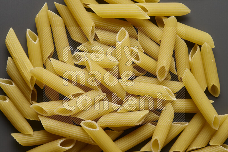 Penne pasta on grey background
