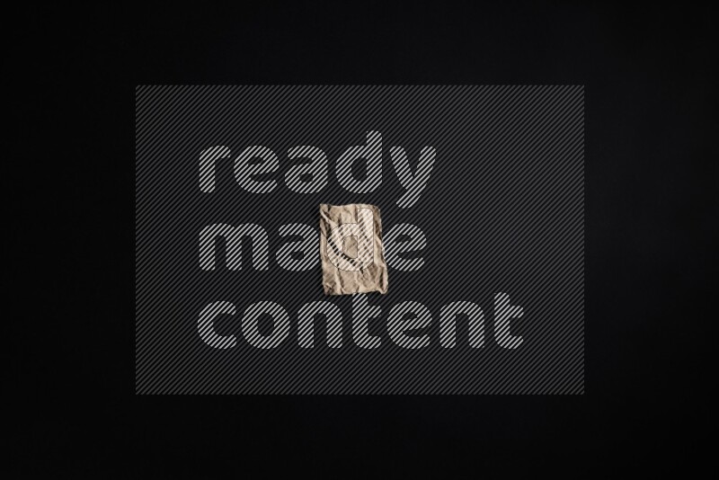 Crumpled craft paper on black background