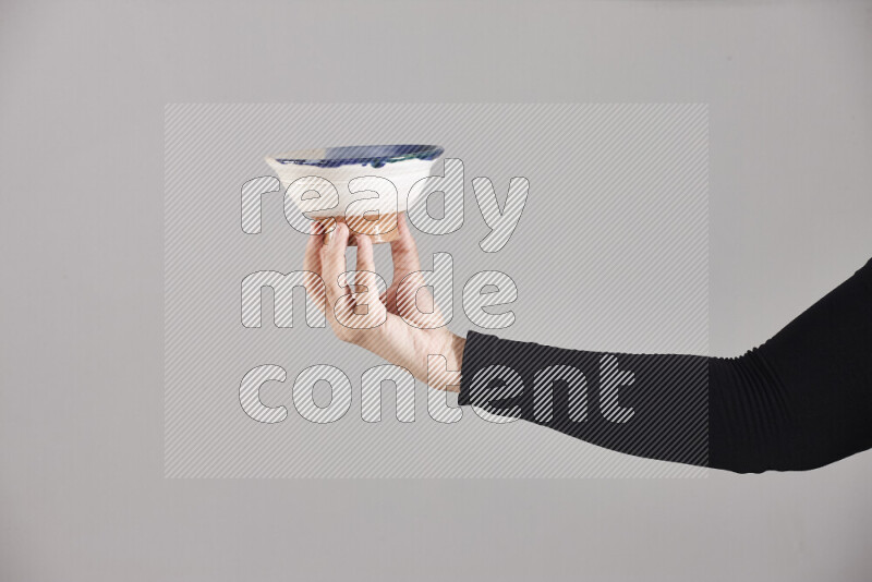 A woman in black abaya holding different pottery essentials in different positions