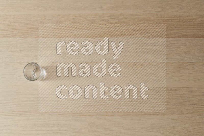 كوب زجاجي فارغ على خلفية خشبية فاتحة