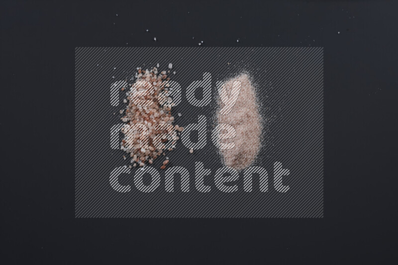 Bunches of table salt, coarse sea salt, fine himalayan salt and coarse himalayan salt on black background