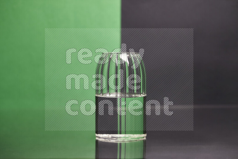 The image features a clear glassware filled with water, set against green and black background