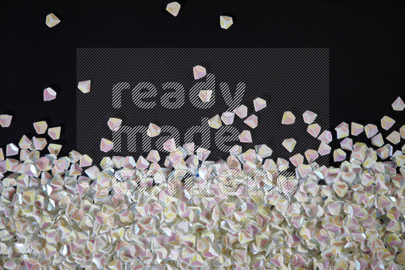 Colorful plastic shards for decoration scattered on a black background
