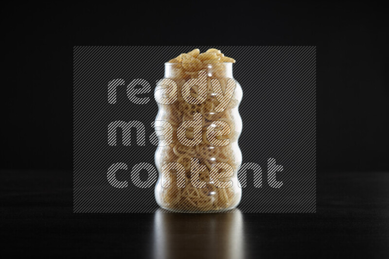 Snacks in a glass jar on black background