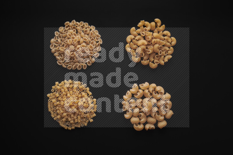 Different pasta types in bunches on black background