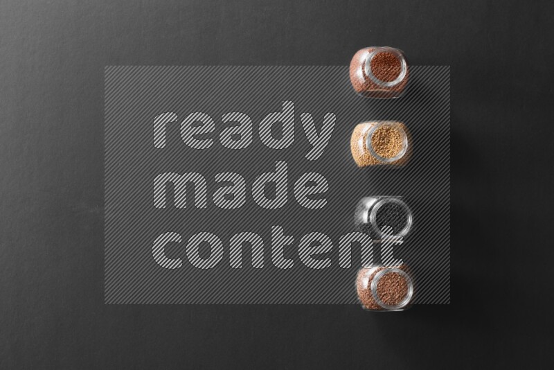 حبة البركة و حبوب الخردل وحبوب الكتان وحب الرشاد في أوعية زجاجية علي خلفية سوداء