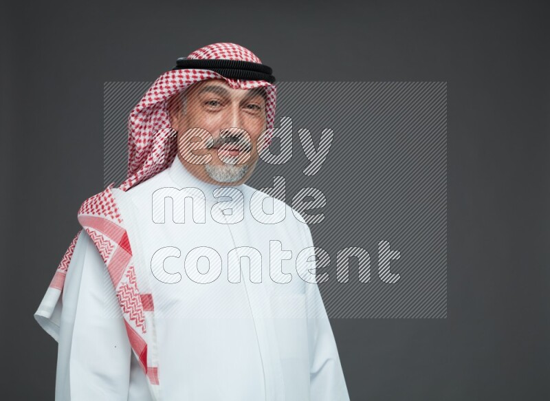 Saudi man with shomag Standing Interacting with the camera on gray background