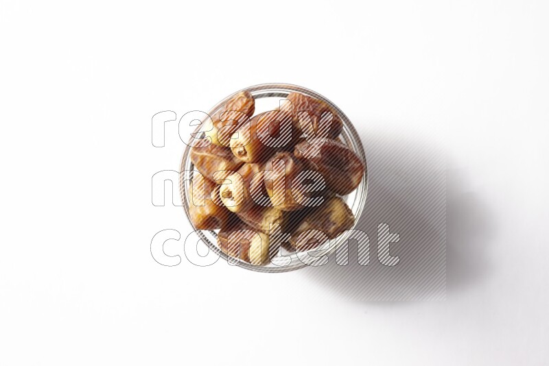 Dates in a glass bowl on white background