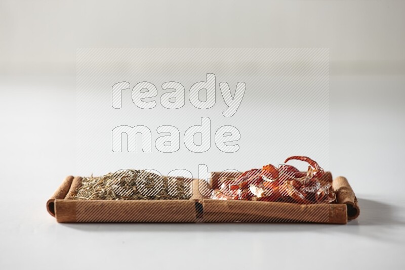 2 squares of cinnamon sticks full of dried red chilis and cumin on white flooring