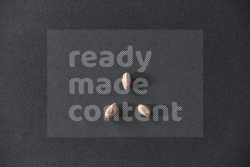 3 peeled pistachios on a black background in different angles