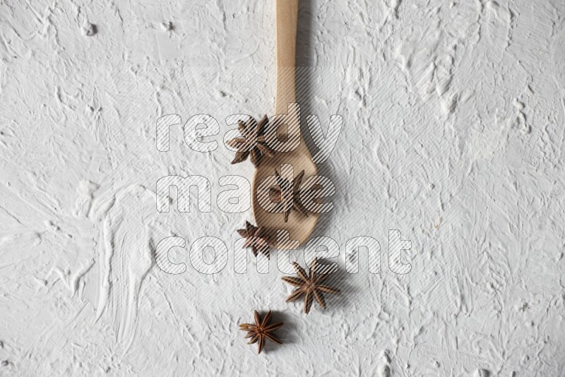 Star Anise in a wooden spoon on white flooring