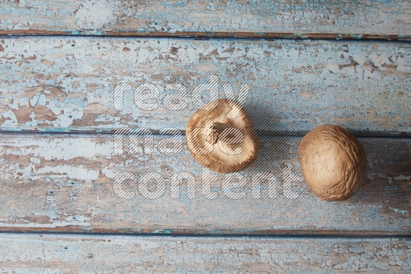 fresh shiitake Mushrooms topview on a light blue wooden textured background