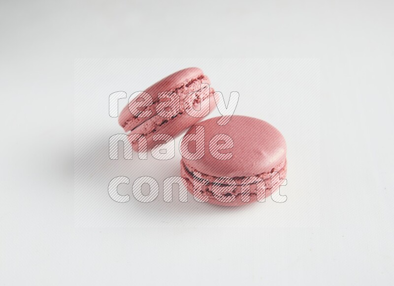 45º Shot of two Pink Raspberry macarons on white background
