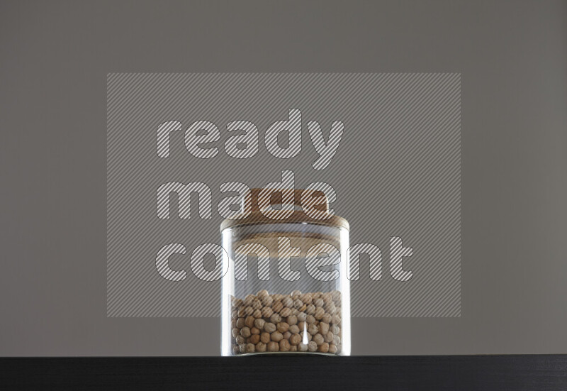 Chickpeas in a glass jar on black background